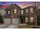 Two-story brick home with a two-car garage and manicured landscaping at 1205 Heartwood Ave, Mcdonough, GA 30253