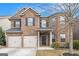 Charming two-story brick home featuring a two-car garage, complemented by a well-manicured front lawn at 1205 Heartwood Ave, Mcdonough, GA 30253