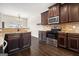 Well-equipped kitchen with stainless steel appliances, dark wood cabinets, and stone tile backsplash at 1205 Heartwood Ave, Mcdonough, GA 30253