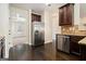 Open kitchen layout with stainless steel appliances, dark wood cabinets, and hardwood floors at 1205 Heartwood Ave, Mcdonough, GA 30253