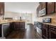 Modern kitchen with stainless steel appliances, dark wood cabinets, and granite countertops at 1205 Heartwood Ave, Mcdonough, GA 30253