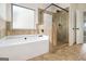A spacious main bathroom with soaking tub and glass enclosed shower and tile surround at 1205 Heartwood Ave, Mcdonough, GA 30253