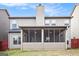 View of the rear exterior of the house with a screened in porch and a backyard at 1205 Heartwood Ave, Mcdonough, GA 30253