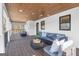 Stylish covered deck with modern furnishings, wood plank ceiling, and views of the surrounding landscape at 459 Lester Rd, Fayetteville, GA 30215