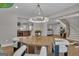 Bright dining room features a modern chandelier, round table, and view to staircase and other living areas at 459 Lester Rd, Fayetteville, GA 30215