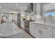 Bright kitchen features white cabinets, stainless steel appliances, and an island with marble countertops at 459 Lester Rd, Fayetteville, GA 30215