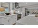 Open kitchen with white cabinetry, stainless steel appliances, and marble countertops next to an open living area at 459 Lester Rd, Fayetteville, GA 30215