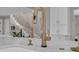 Kitchen sink with elegant gold faucet, set in white marble countertop island with stairs in background at 459 Lester Rd, Fayetteville, GA 30215