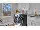 Well-lit laundry room with modern appliances, storage, and a scenic lake view at 459 Lester Rd, Fayetteville, GA 30215