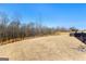 Expansive backyard featuring a large grassy area with a wooded backdrop, and trampoline in the distance at 755 Gelderland Dr, Hampton, GA 30228