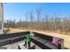 Outdoor patio with modern dark wicker furniture and wooded backyard at 755 Gelderland Dr, Hampton, GA 30228