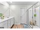 Bright bathroom with a double sink vanity, hard surface floor, and glass shower enclosure at 755 Gelderland Dr, Hampton, GA 30228