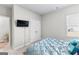 A bright bedroom features neutral walls, and a comfortable bed with closet and mounted TV at 755 Gelderland Dr, Hampton, GA 30228