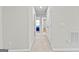Well-lit hallway with neutral walls and carpet leads to rooms with closed and open doors at 755 Gelderland Dr, Hampton, GA 30228
