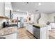 Modern kitchen with stainless steel appliances, white cabinetry, and a view of the living area at 755 Gelderland Dr, Hampton, GA 30228