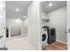 Hallway view of the laundry room with modern washer and dryer, overhead shelving at 755 Gelderland Dr, Hampton, GA 30228