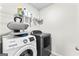 Modern laundry room with front load washer and dryer, shelving and ironing station at 755 Gelderland Dr, Hampton, GA 30228