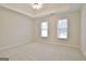 A bright bedroom features neutral carpeting, tray ceiling and two windows at 112 Windalier Rdg, Peachtree City, GA 30269