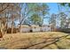 Large backyard with mature trees, fenced perimeter, and home exterior featuring siding at 6071 Cristie Dr, Ellenwood, GA 30294