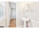 Well-lit bathroom featuring a pedestal sink, wood-look floors, and beadboard paneling at 6071 Cristie Dr, Ellenwood, GA 30294