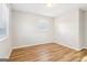 A bright bedroom with wood-look flooring and a window with blinds that offers natural light and privacy at 6071 Cristie Dr, Ellenwood, GA 30294