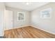 A bright bedroom with wood-look flooring, two windows, and neutral paint creates a serene and inviting atmosphere at 6071 Cristie Dr, Ellenwood, GA 30294