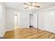 A bright bedroom featuring wood-look flooring, ceiling fan, and en-suite bathroom creating a comfortable space at 6071 Cristie Dr, Ellenwood, GA 30294