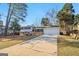 This property boasts a long driveway leading up to an attached garage, complemented by a generous front lawn at 6071 Cristie Dr, Ellenwood, GA 30294