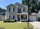 Charming two-story home with gray siding, black shutters, a front porch, and manicured landscaping at 5425 Twin Lakes Dr, Atlanta, GA 30349