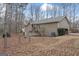 View of the backyard featuring a fire pit, chain link fence, and wooded surroundings at 122 Doe Run Dr, Sharpsburg, GA 30277