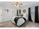 Cozy main bedroom featuring a ceiling fan and a king-sized bed with decorative pillows at 122 Doe Run Dr, Sharpsburg, GA 30277