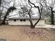 Backyard view of home with a grey brick exterior and a concrete parking pad at 3376 Brookfield Ln, Decatur, GA 30032