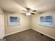 Cozy bedroom with carpet flooring and neutral walls, illuminated by a ceiling fan and natural light from two windows at 3376 Brookfield Ln, Decatur, GA 30032