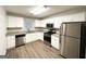 Well-lit kitchen with stainless steel appliances, granite countertops, and white cabinets at 3376 Brookfield Ln, Decatur, GA 30032