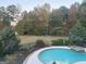 Scenic view of the backyard with lush greenery, swimming pool, and a glimpse of deer in the distance at 39 Hannah Way, Palmetto, GA 30268