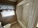 Bathroom with a white shower-tub and tiled flooring and a window with blinds at 160 Appalachee Church Rd, Auburn, GA 30011