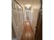Long hallway with hardwood floors and multiple doors leading to various rooms at 160 Appalachee Church Rd, Auburn, GA 30011