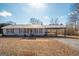 Charming home featuring a metal roof, red shutters, and covered parking with a deck at 382 Lamb Rd, Moreland, GA 30259