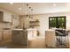 Bright kitchen with marble island, wooden accents, stainless steel appliances, pendant lighting, and a view to the backyard at 330 Campground Rd, Mcdonough, GA 30253