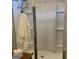 Modern glass enclosed shower with tiled walls, convenient shelving, and a towel rack at 9135 Gladwyne Xing, Villa Rica, GA 30180