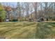 Green backyard provides plenty of space for recreational activities with trampoline, shed, and storage at 185 Redwood Cir, Fayetteville, GA 30214