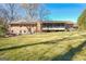 Expansive backyard view of a brick house with a sunroom at 185 Redwood Cir, Fayetteville, GA 30214