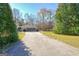 Long driveway leading to a home with a side entry garage and mature trees at 185 Redwood Cir, Fayetteville, GA 30214