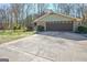 Attached garage with mature trees, driveway and lawn at 185 Redwood Cir, Fayetteville, GA 30214