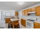 Bright kitchen features an island with seating, wooden cabinets, and white appliances at 825 Karie Dr, Mcdonough, GA 30253
