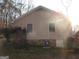 Rear exterior of home with two windows, set on a small foundation, and an A/C unit at 5848 Navarre Ct, Stone Mountain, GA 30087