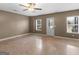 Spacious living room with two large windows, a white door, a ceiling fan and light brown walls at 70 Caseys Way, Covington, GA 30014