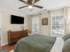 This lovely bedroom boasts hardwood floors, a ceiling fan, and lots of natural light from the windows at 144 Wyckliffe Dr, Locust Grove, GA 30248