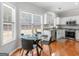 Cozy dining area features hardwood floors, modern table, and a bright kitchen at 144 Wyckliffe Dr, Locust Grove, GA 30248