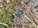 A direct aerial view of this home shows it centrally placed among many trees and a winding driveway at 2999 Happy Hollow Se Dr, Conyers, GA 30094